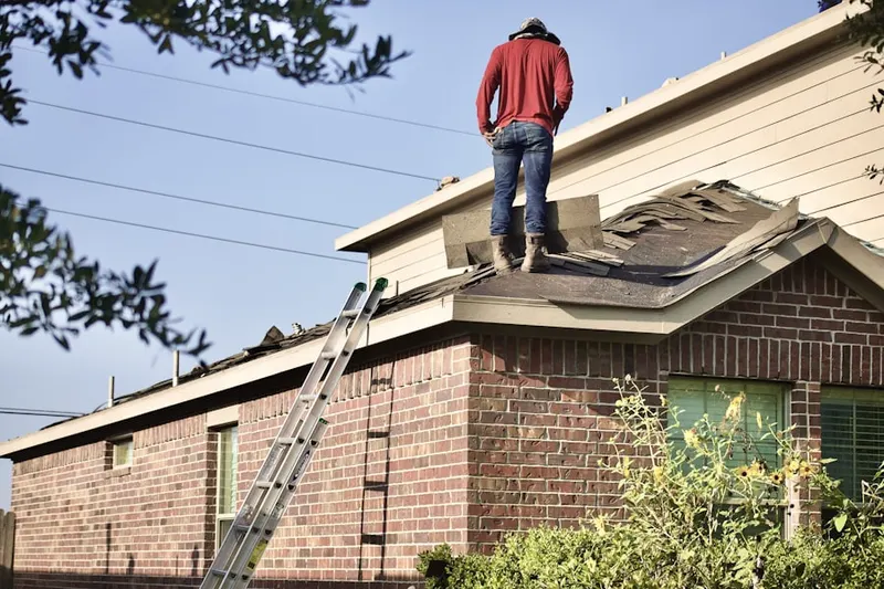 Professional roofer working on a residential roof in Jones